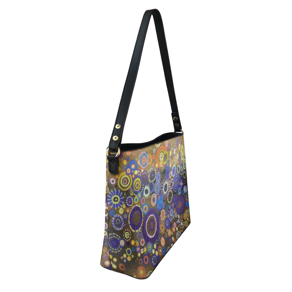 Shoulder bag with brilliant circles and interlocking stars over mustard painting