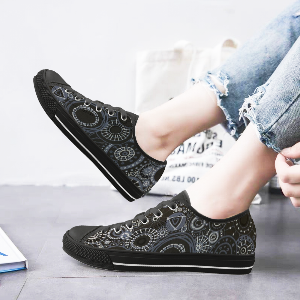 Sneakers with black features and all over pattern in greys and blacks. with model